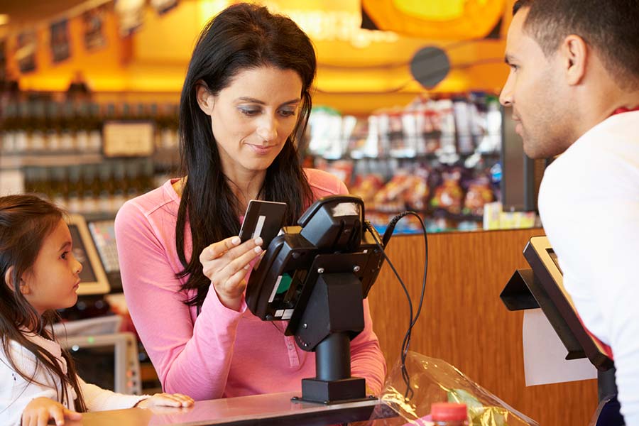 Mom using her Debit Card at the Grocery Store